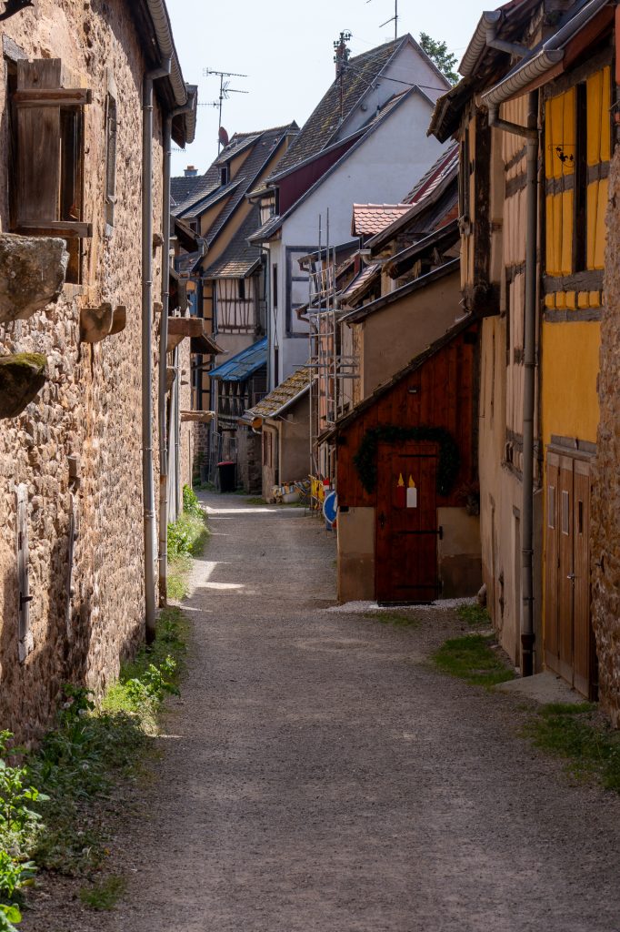 Schmale mittelalterliche Gasse mit Fachwerkhäusern in Eguisheim