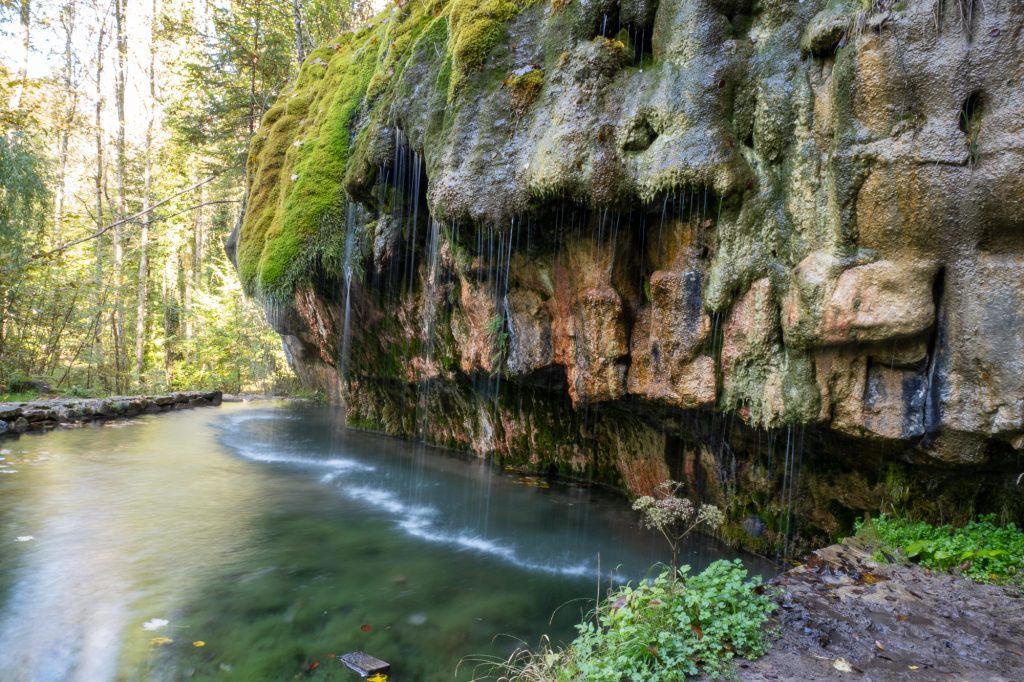 Langzeitbelichtung von Wasser an einer moosbewachsenen Sandsteinwand im Müllerthal